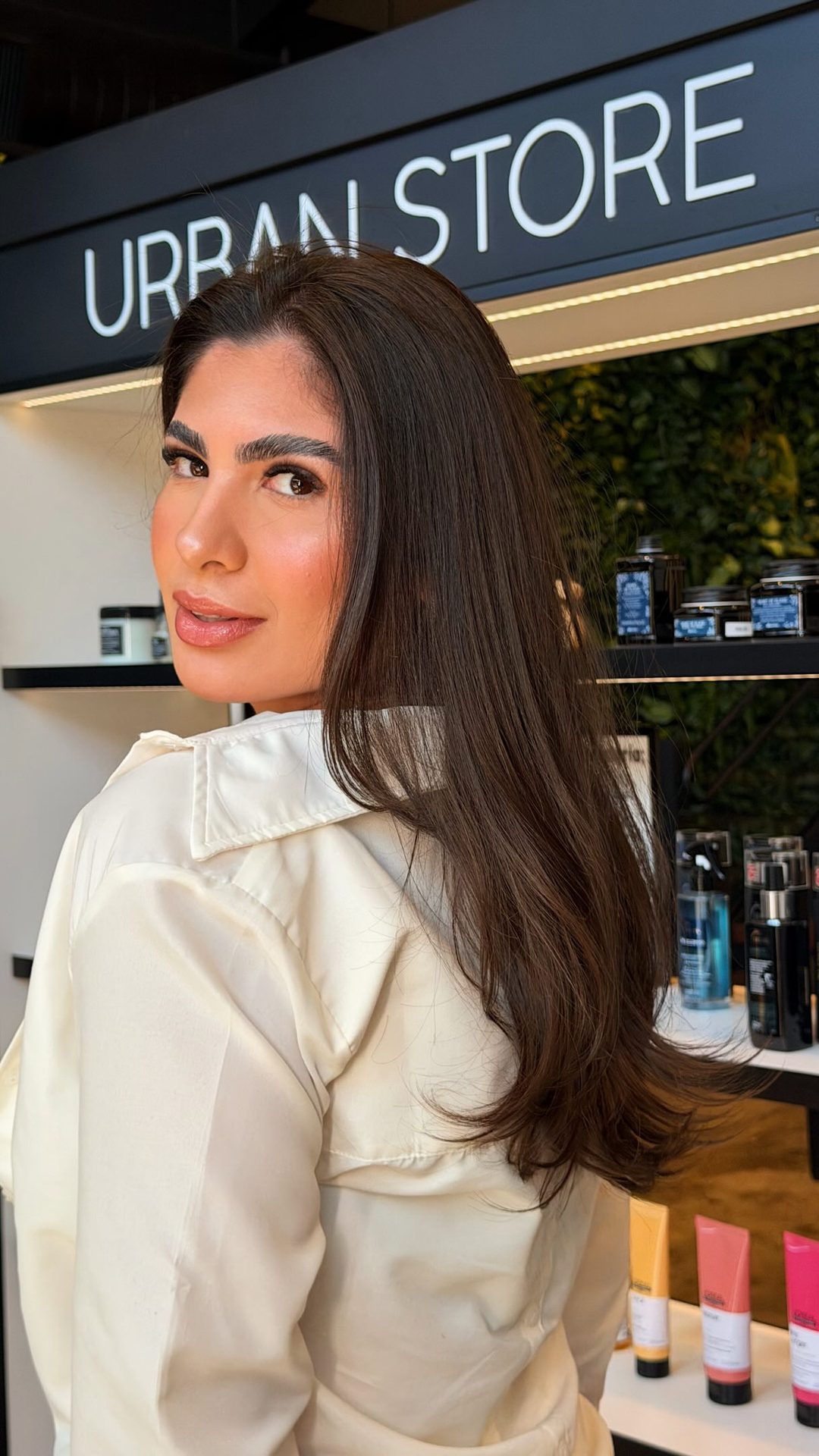 Cliente de cabelo castanho liso em frente à Urban Store